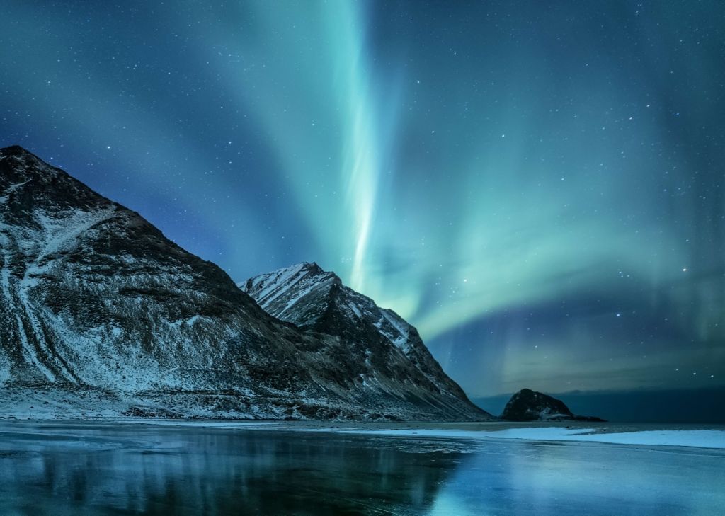 Des aurores boréales vertes au-dessus des montagnes