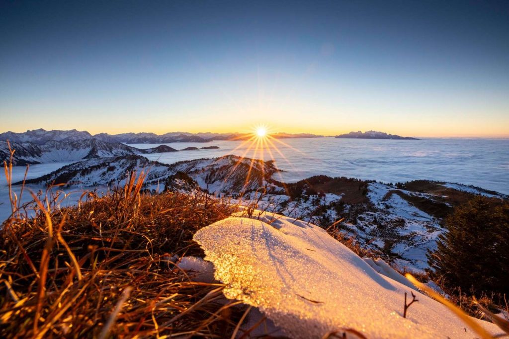 Lever de soleil au-dessus d'une prairie de montagne en hiver