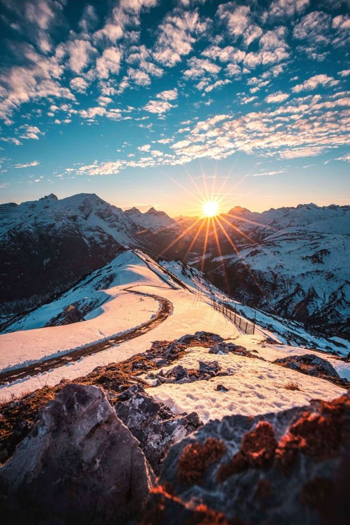 Sentier sinueux sous le soleil de montagne enneigée.