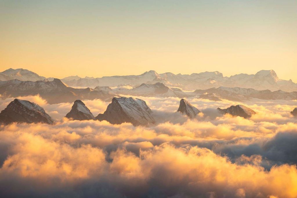 Les sommets des montagnes au-dessus de la mer de nuages dorés.