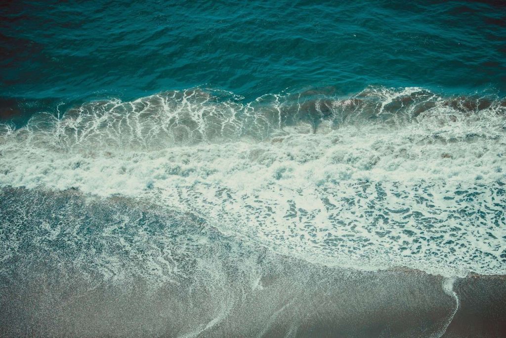 Vagues moussantes sur le sable mouillé
