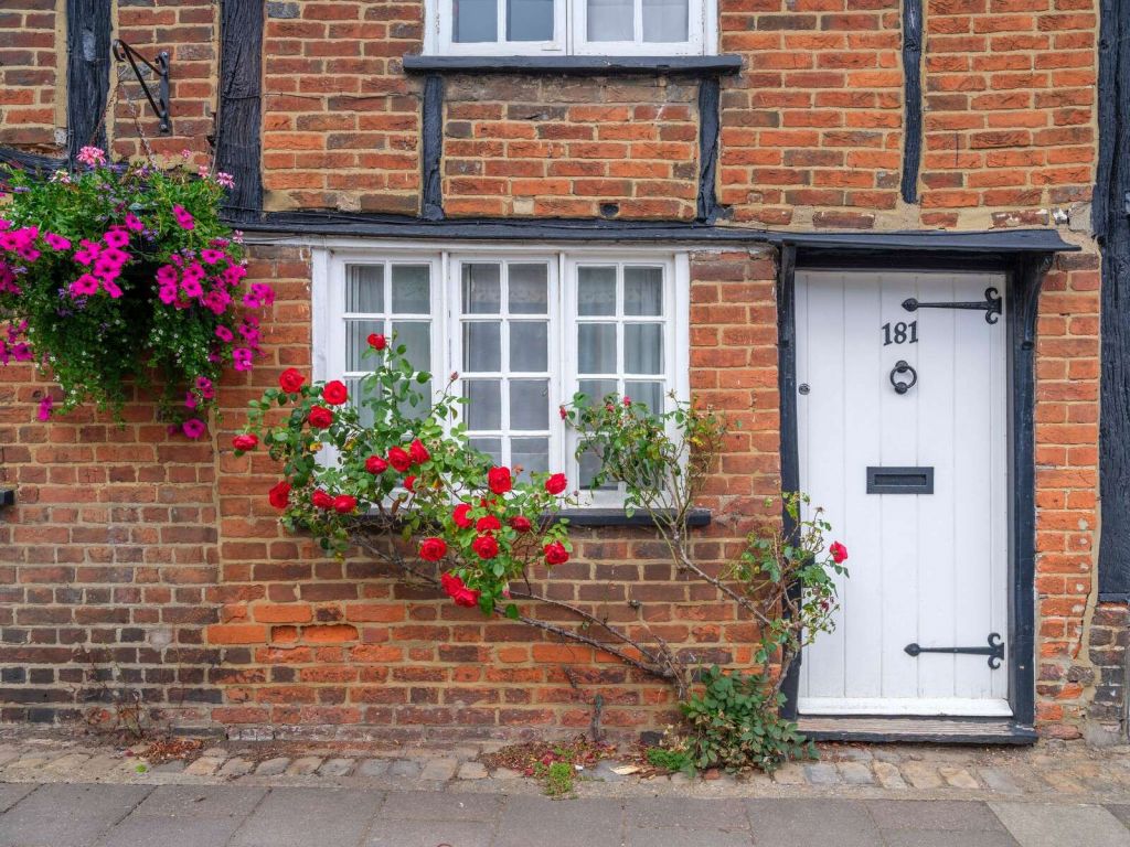 cottage en briques avec des roses rouges