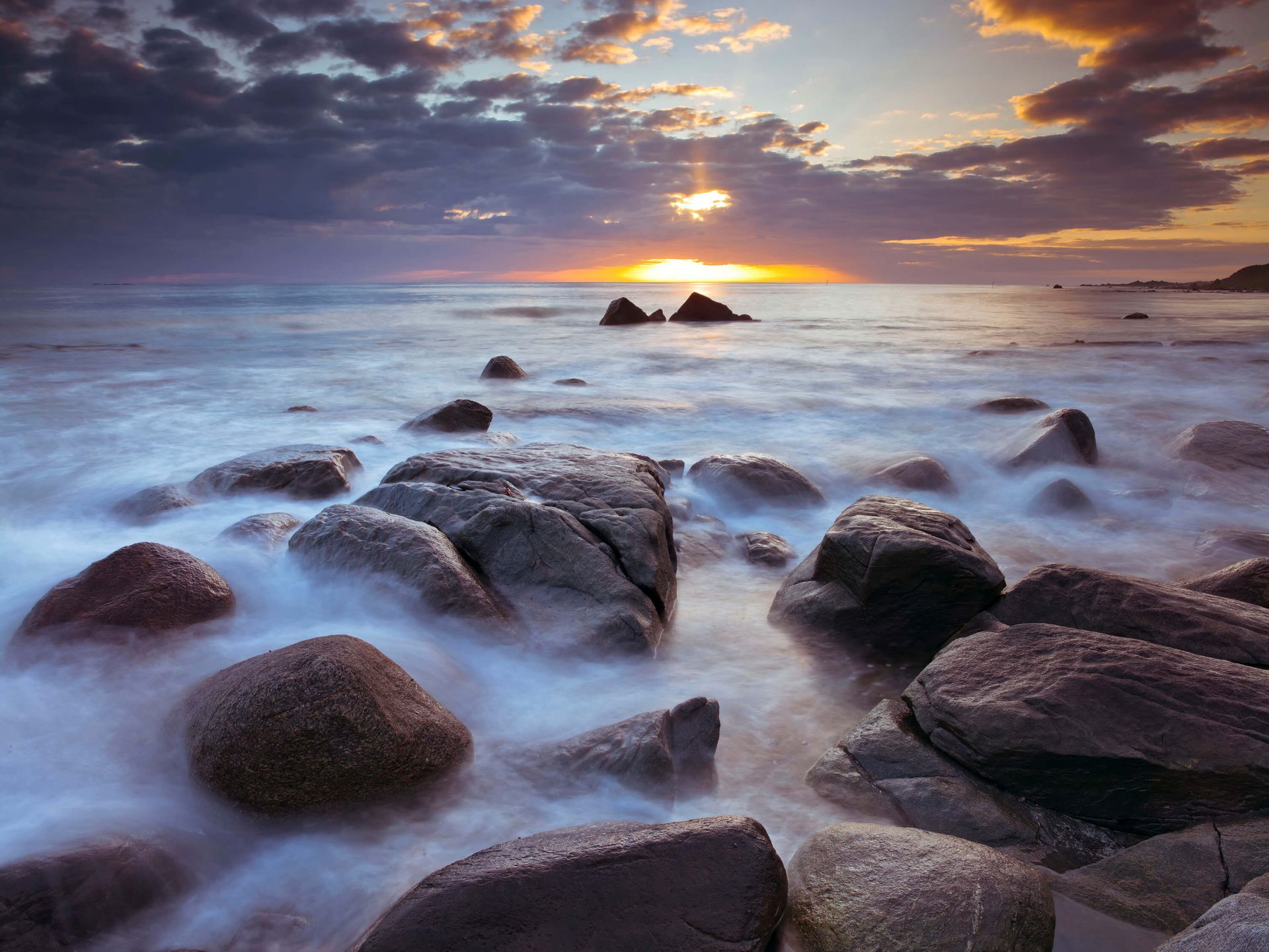 Coucher de soleil sur une côte rocheuse main product photo
