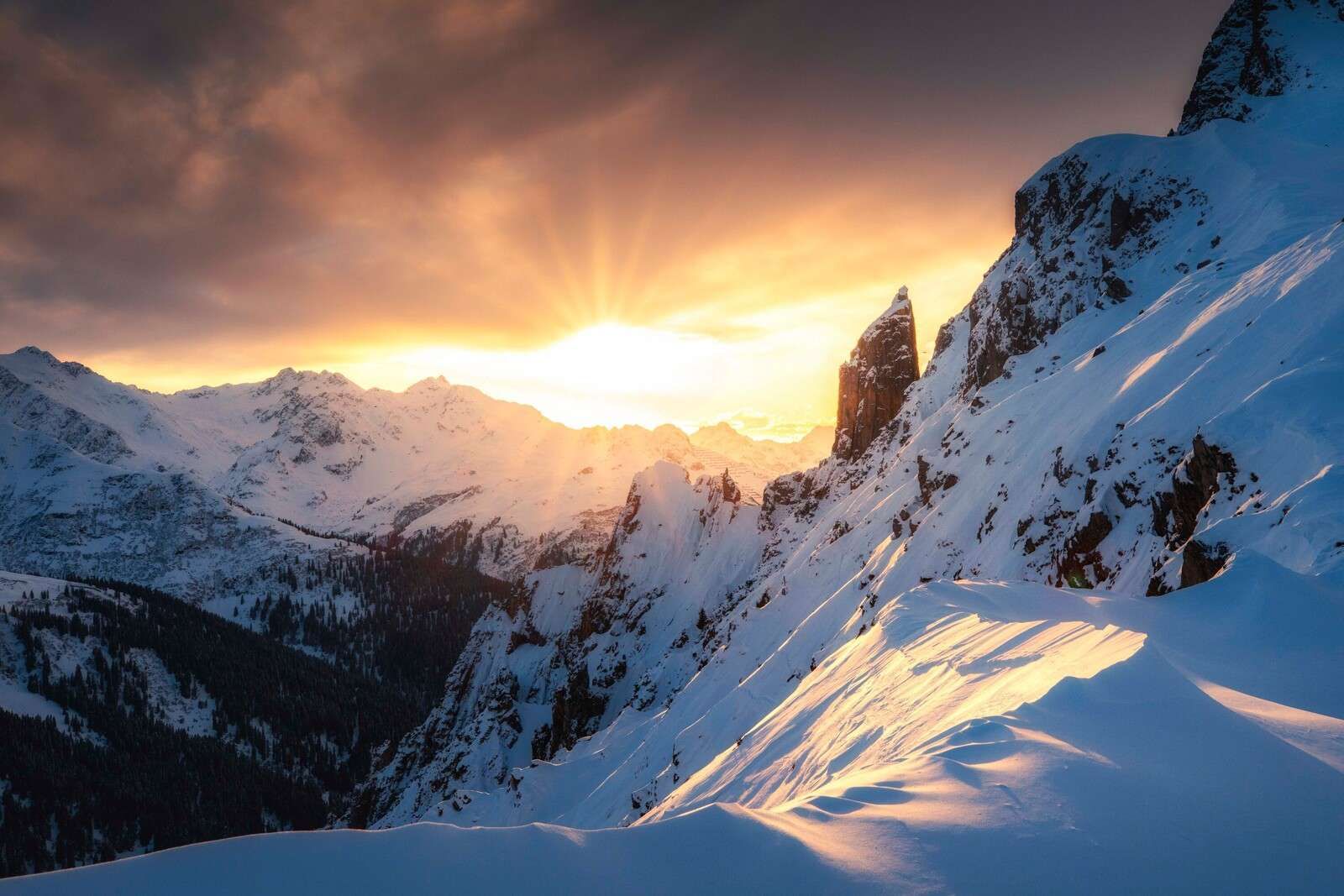 Soleil du soir derrière les sommets enneigés
