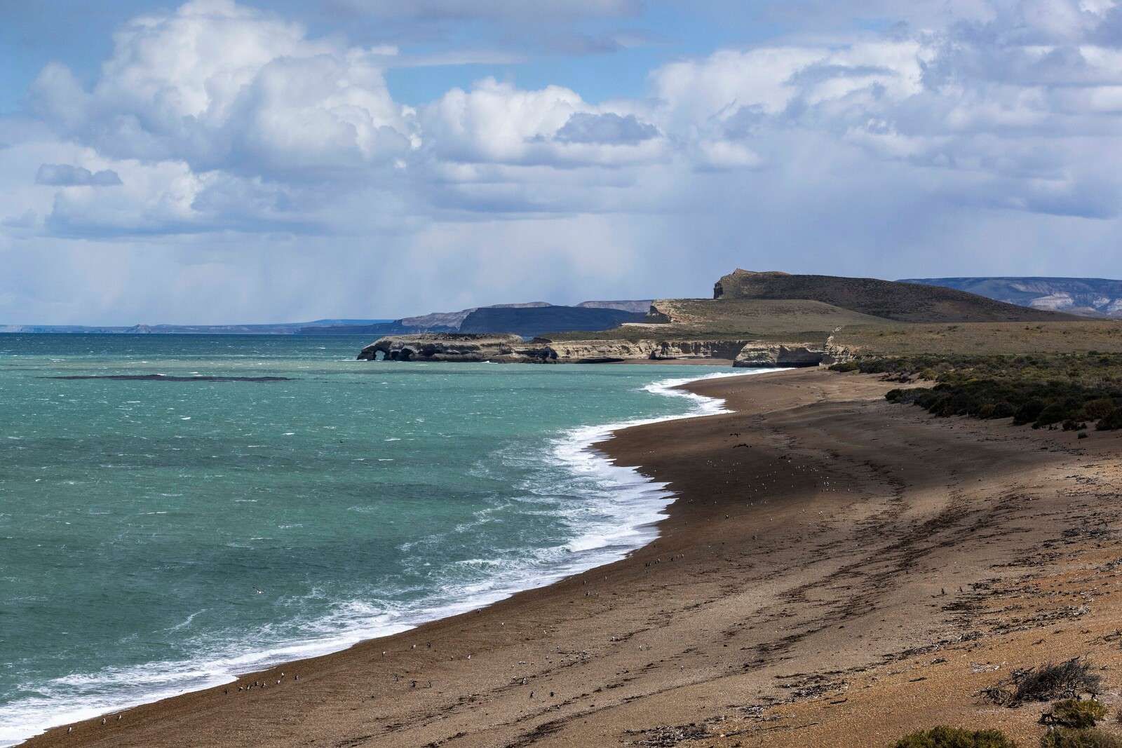 Côte escarpée avec mer turquoise.