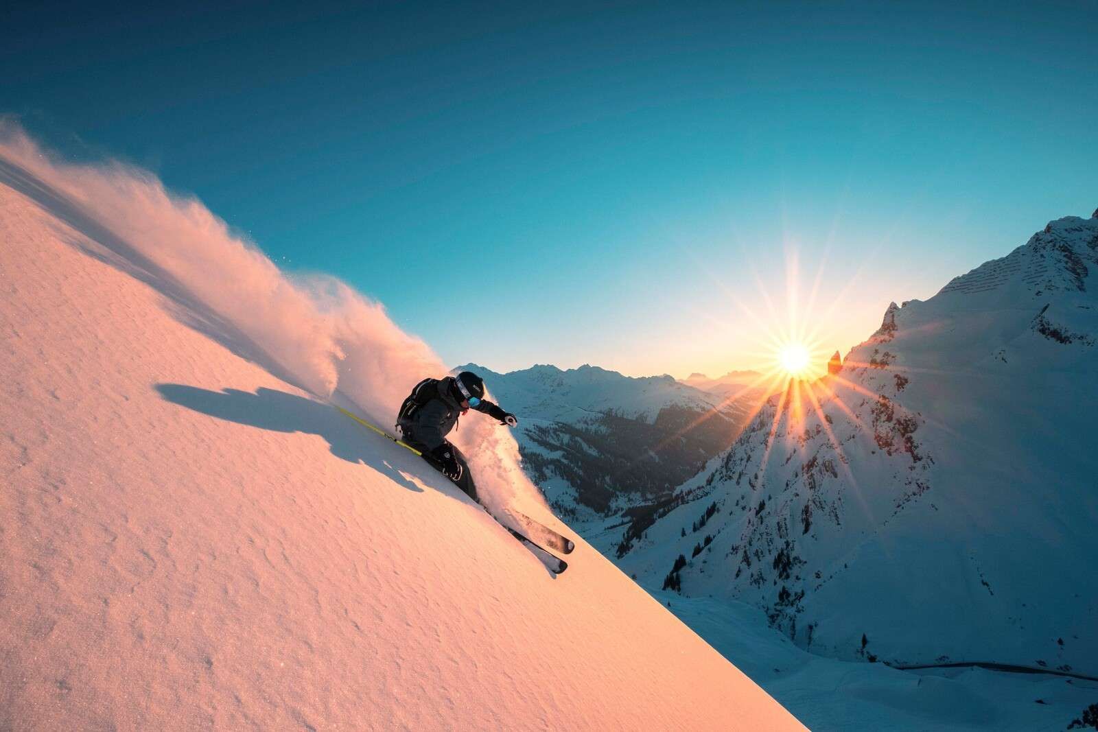 Descente enneigée au coucher du soleil enflammé.