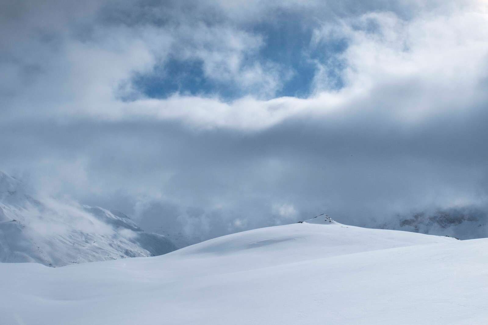 Collines enneigées sous un ciel menaçant